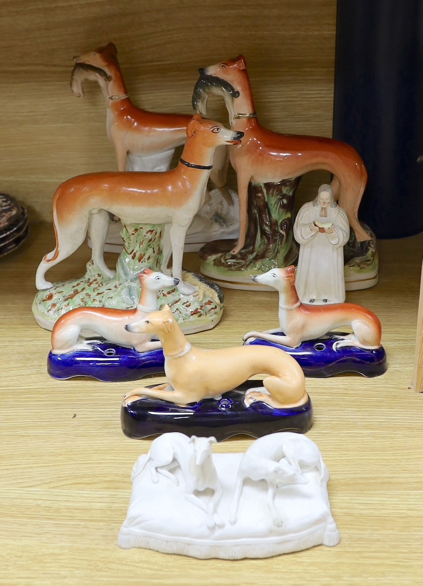 A Staffordshire pottery figure of John Wesley, six Staffordshire pottery models of hounds, and a white bisque group of two hounds on a cushion, tallest 29cm, (8)